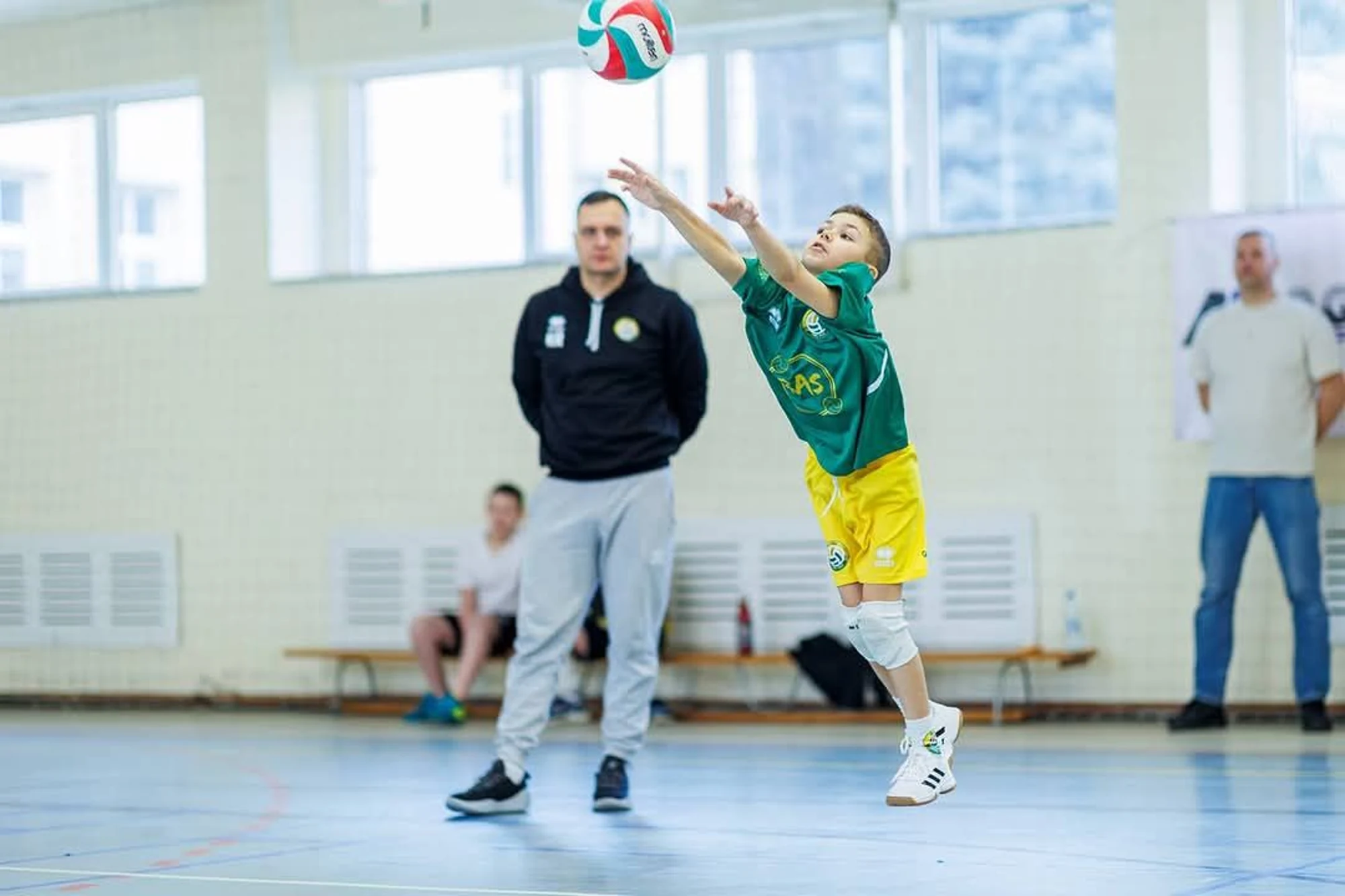 Młody zawodnik BAS odbija piłkę pod okiem trenera